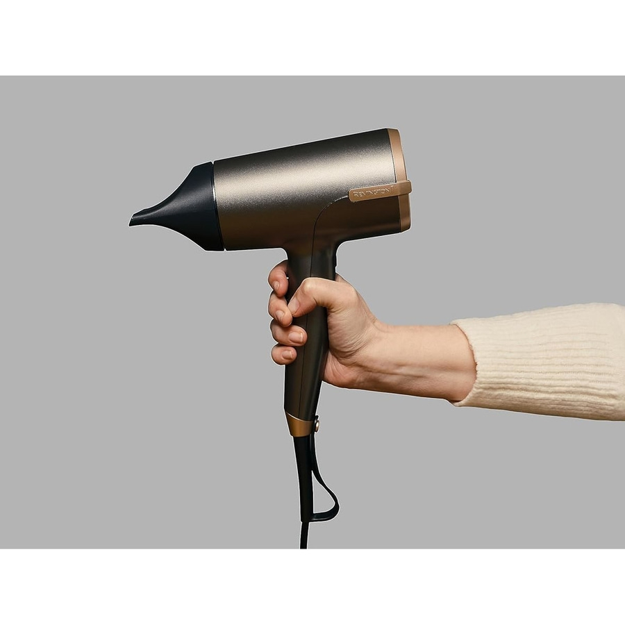 Eine Hand hält einen dunklen Remington-Haartrockner mit einem schmalen Aufsatz.