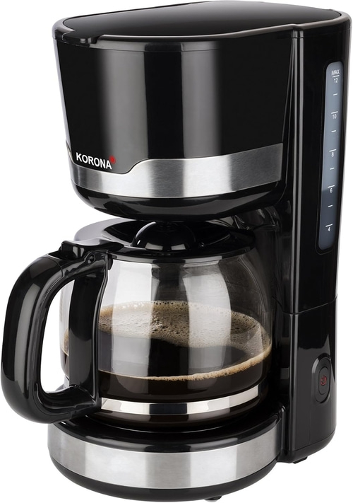 Schwarze Kaffeemaschine mit Glaskanne und Korona-Logo, Kaffee zubereitet.