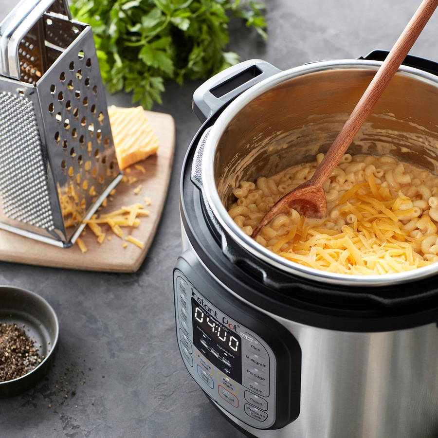 Instant Pot mit Makkaroni und Käse, Käse gerieben, Kochutensilien, Essen zubereiten