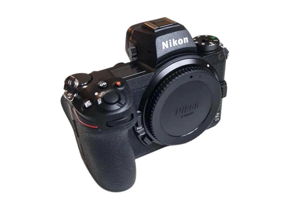 Nikon Kamera mit Objektivdeckel vor weißem Hintergrund