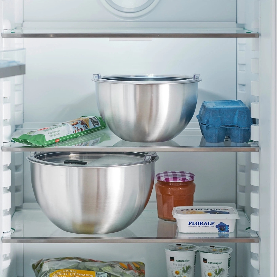 Kühlschrank mit Lebensmitteln: Schüsseln, Eier, Butter, Joghurt, Gemüse, Pasta.