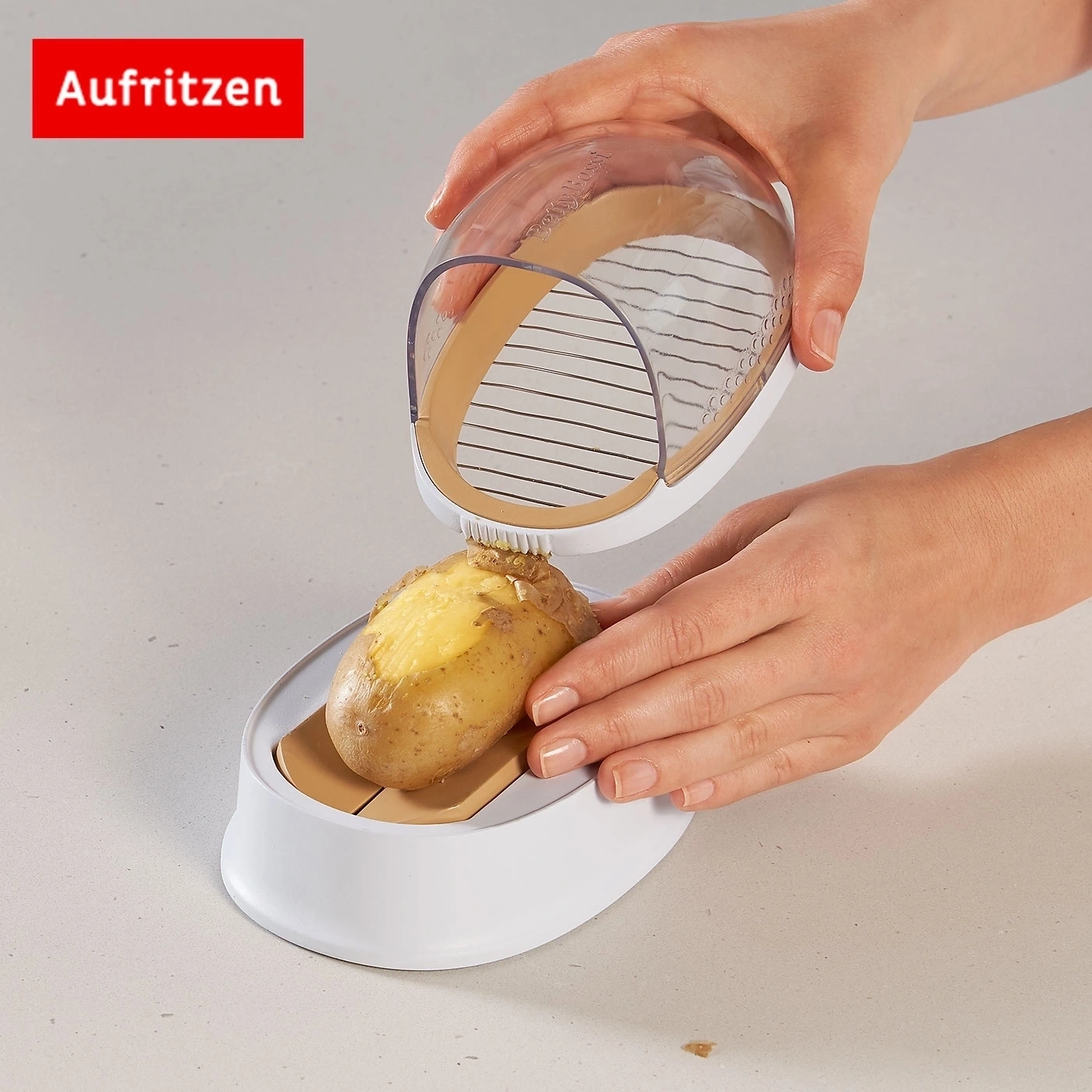 Person schneidet Kartoffel mit einem speziellen Küchengerät auf einer hellen Oberfläche.