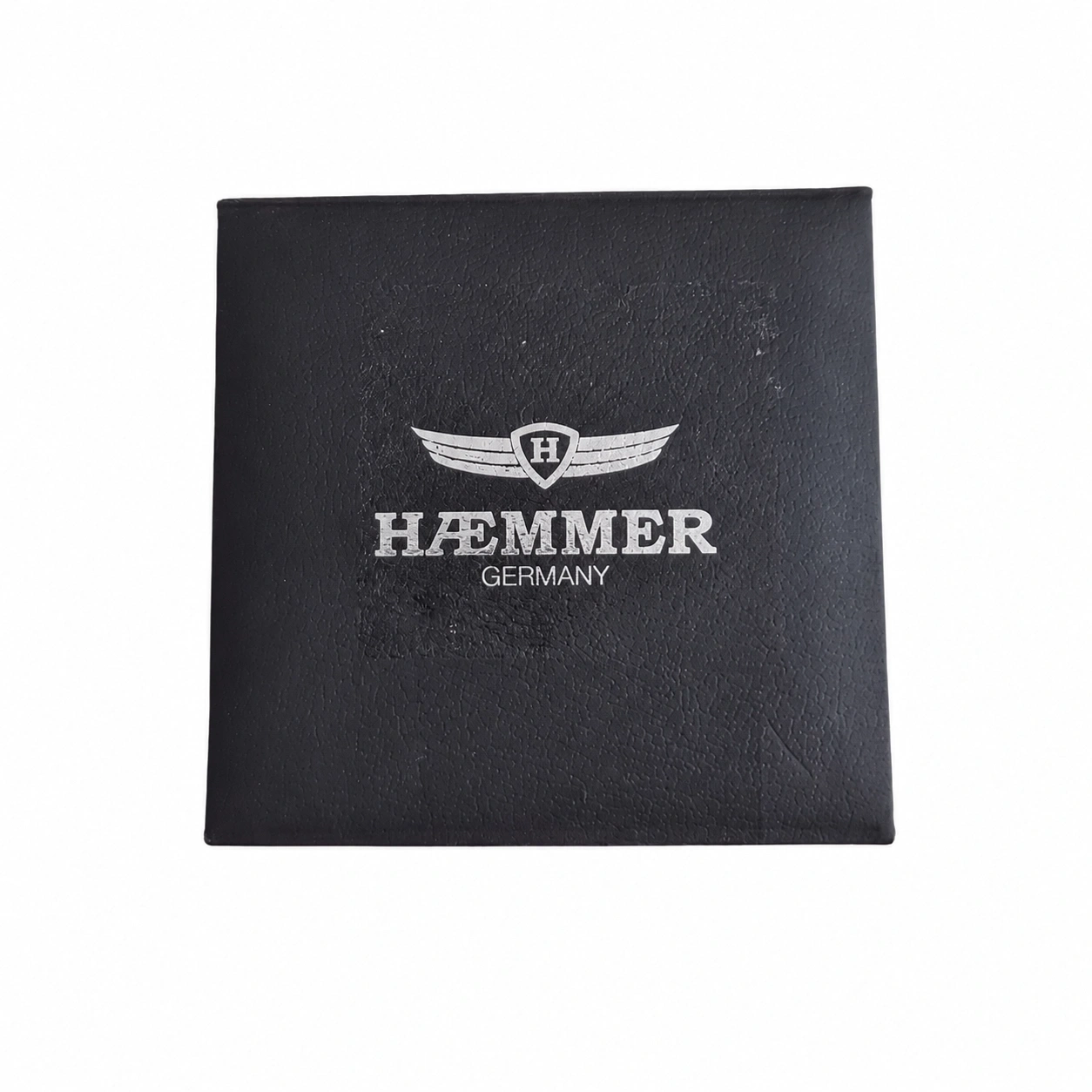Schwarze Box mit silbernem Emblem und Schriftzug "HÄMMER GERMANY".