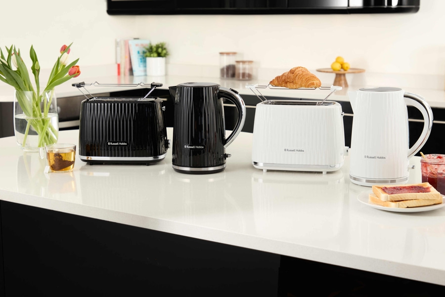 Küchenszene mit Toastern, Wasserkochern, Croissant, Toast und Blumen auf einer Arbeitsplatte