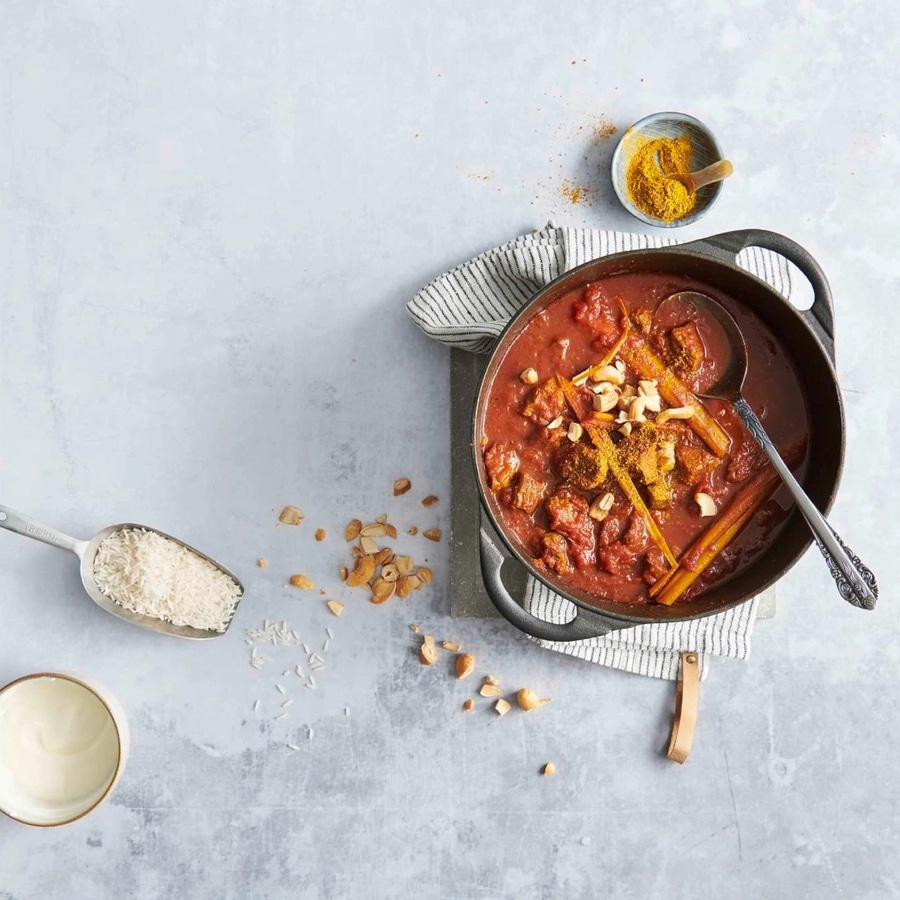 Eintopf mit Reis, Cashewnüssen und Gewürzen in einer Pfanne serviert