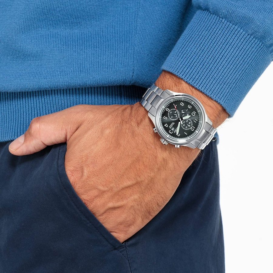 Mann mit Uhr und blauer Kleidung, die in die Hosentasche greift