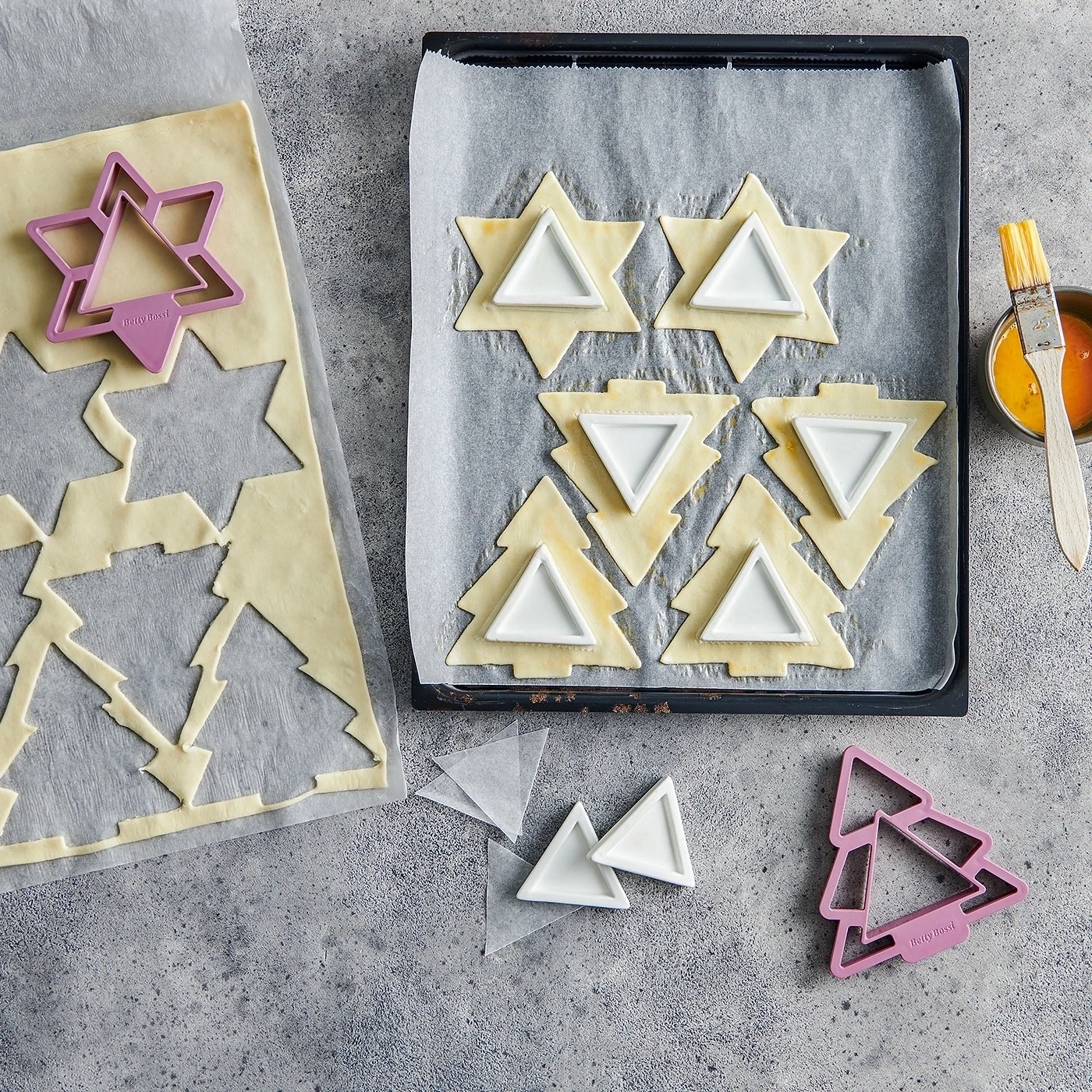 Weihnachtsplätzchen vorbereiten: Teig, Ausstecher, Backblech, Pinsel, Eigelb.