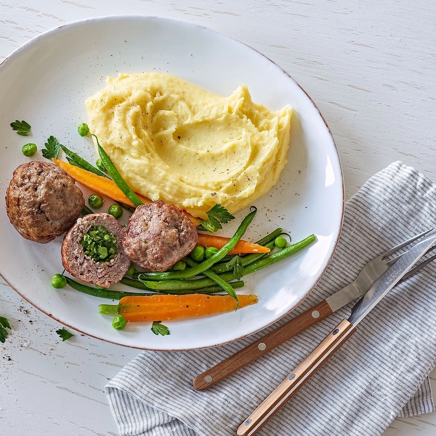 Teller mit Fleischbällchen, Kartoffelpüree und Gemüse. Köstliches Essen.