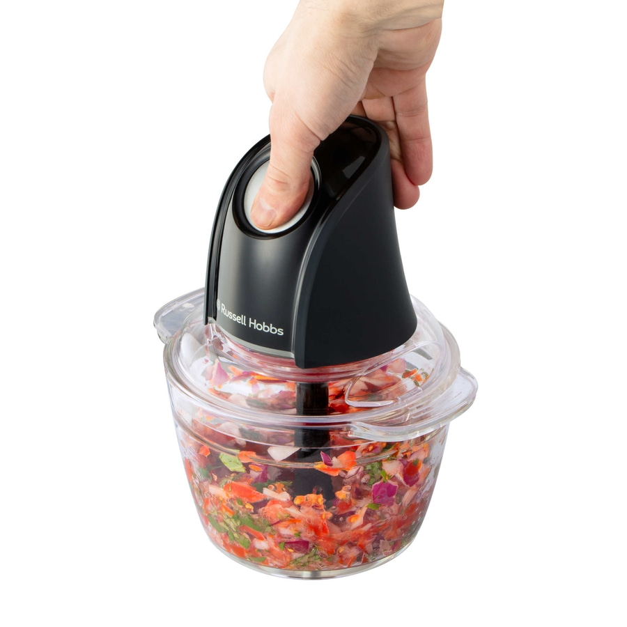 Hand hält einen schwarzen Zerkleinerer mit Gemüse, Russell Hobbs