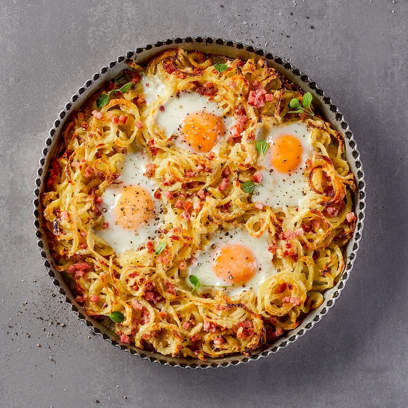 Gebratene Eier mit Kartoffeln und Speck in einer Kuchenform