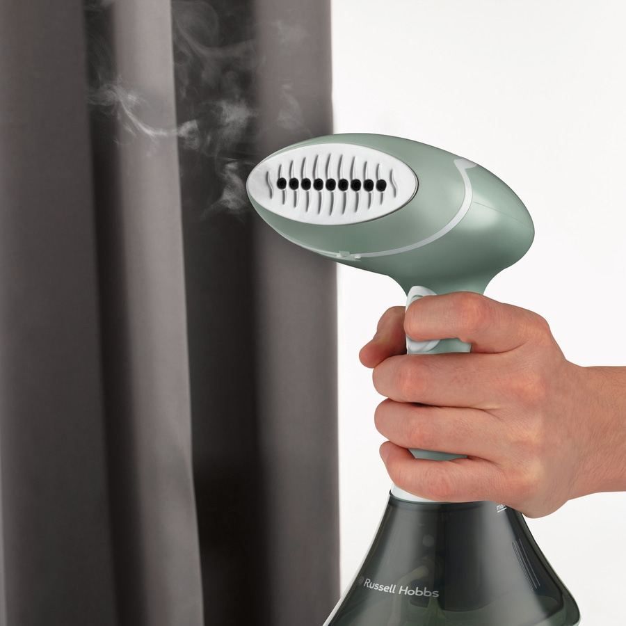 Handdampfgerät, das Dampf auf einen grauen Vorhang sprüht, Russell Hobbs