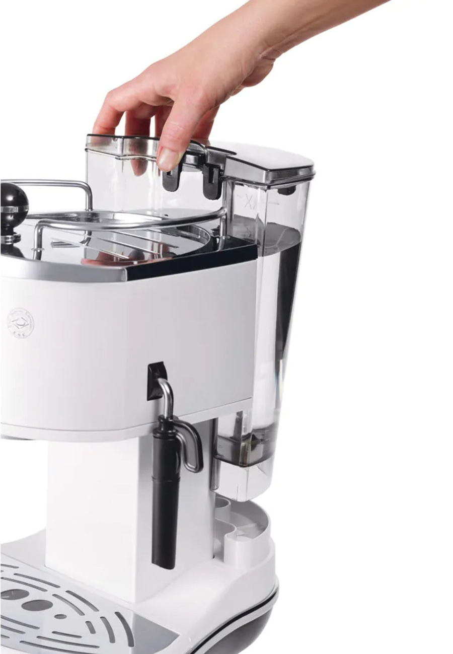 Ein Teil einer weißen Kaffeemaschine mit einem Wasserbehälter und einer Hand, die ihn einsetzt.