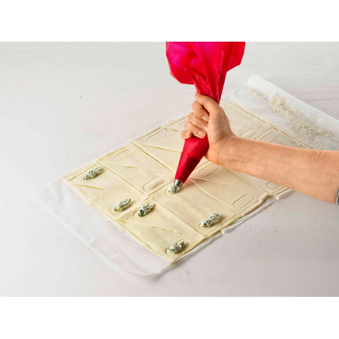 Person füllt Teig mit Creme aus einem Spritzbeutel. Backen.