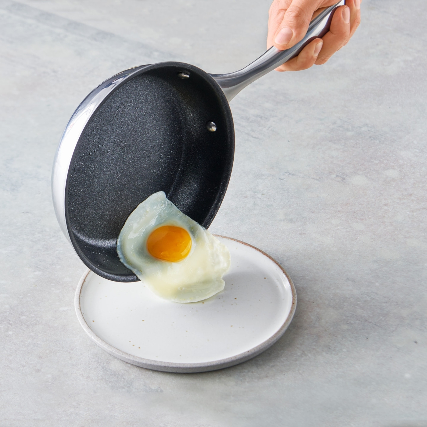 Ei wird aus der Pfanne auf einen Teller gelegt. Essen zubereiten.