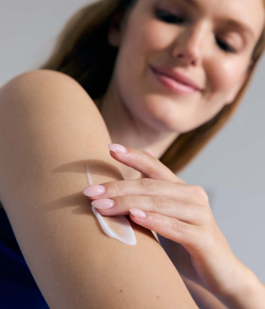 Frau trägt Creme auf ihren Arm auf, Hautpflege, Schönheit, Wellness