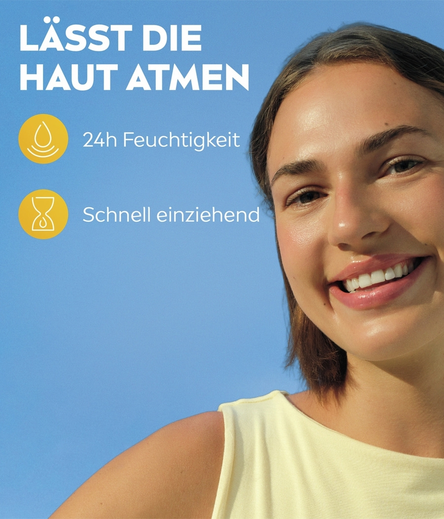 Eine lächelnde Frau mit Sonnenlicht auf ihrem Gesicht und blauem Himmel im Hintergrund.