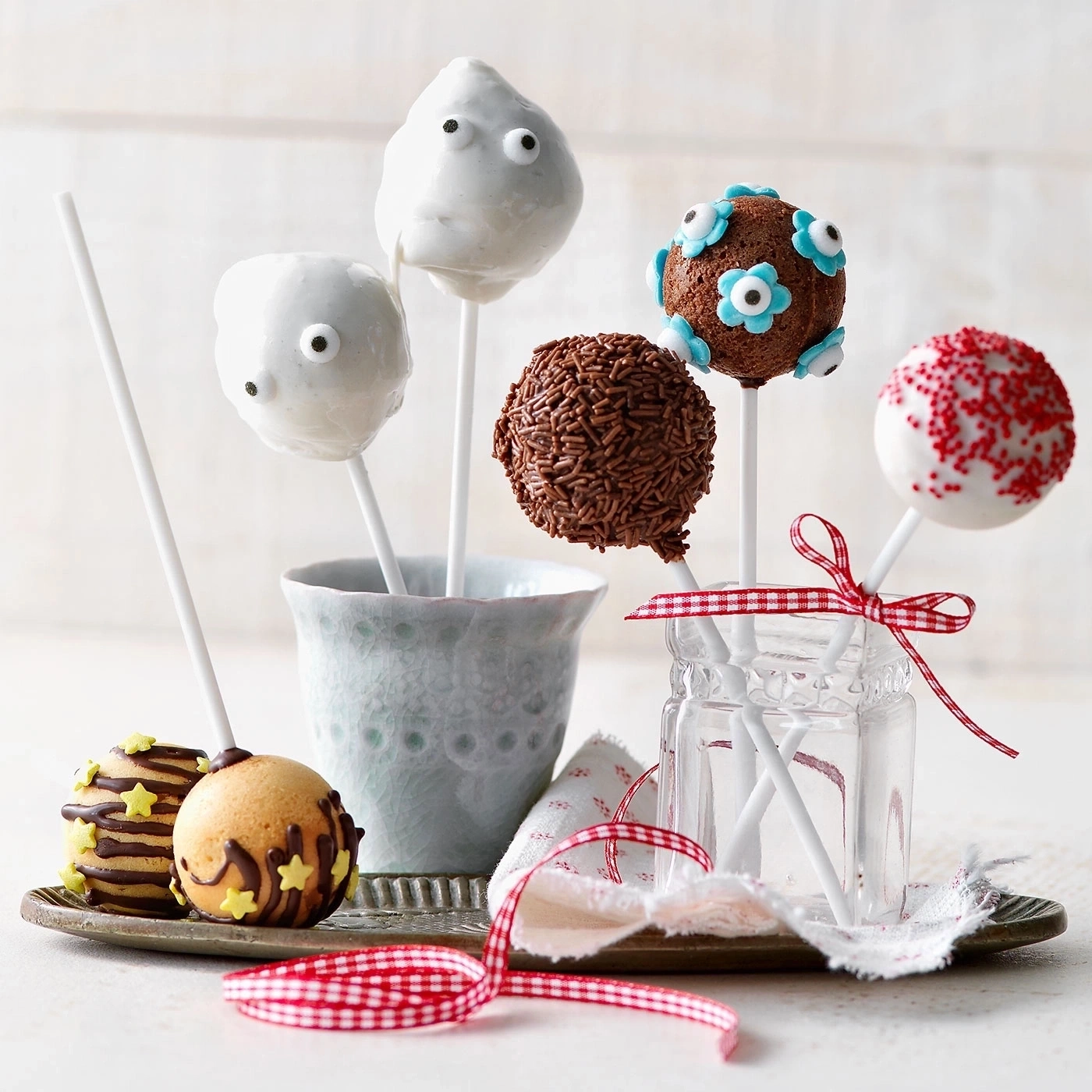 Köstliche Cake Pops, dekoriert mit verschiedenen Verzierungen, auf einem Tablett präsentiert.