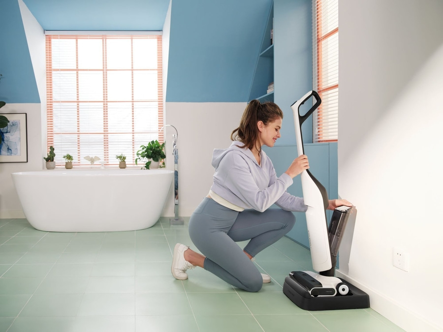 Frau mit Staubsauger in einem Badezimmer