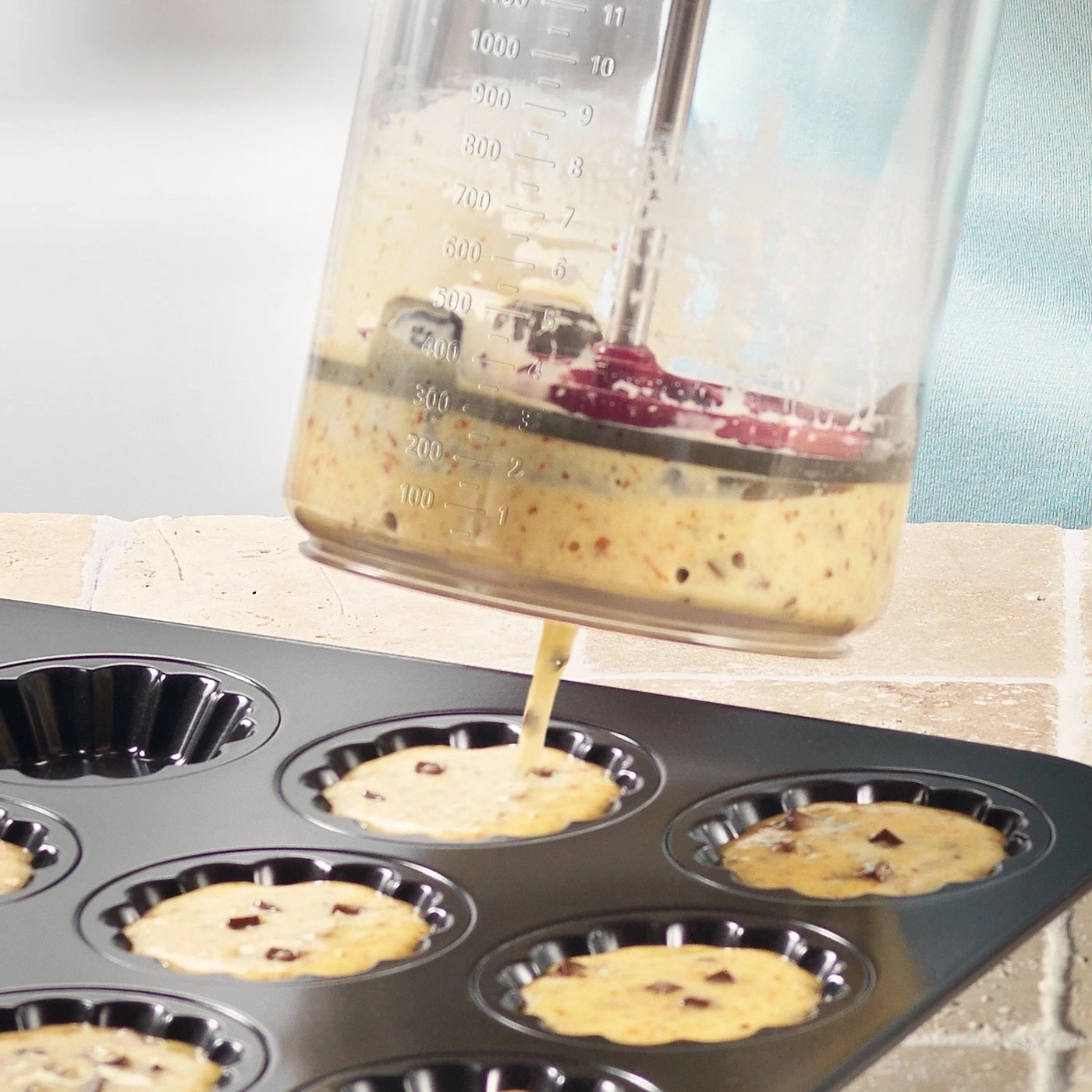 Teig wird in eine Backform gegossen, um Muffins zu backen. Küche, Backen, Essen.