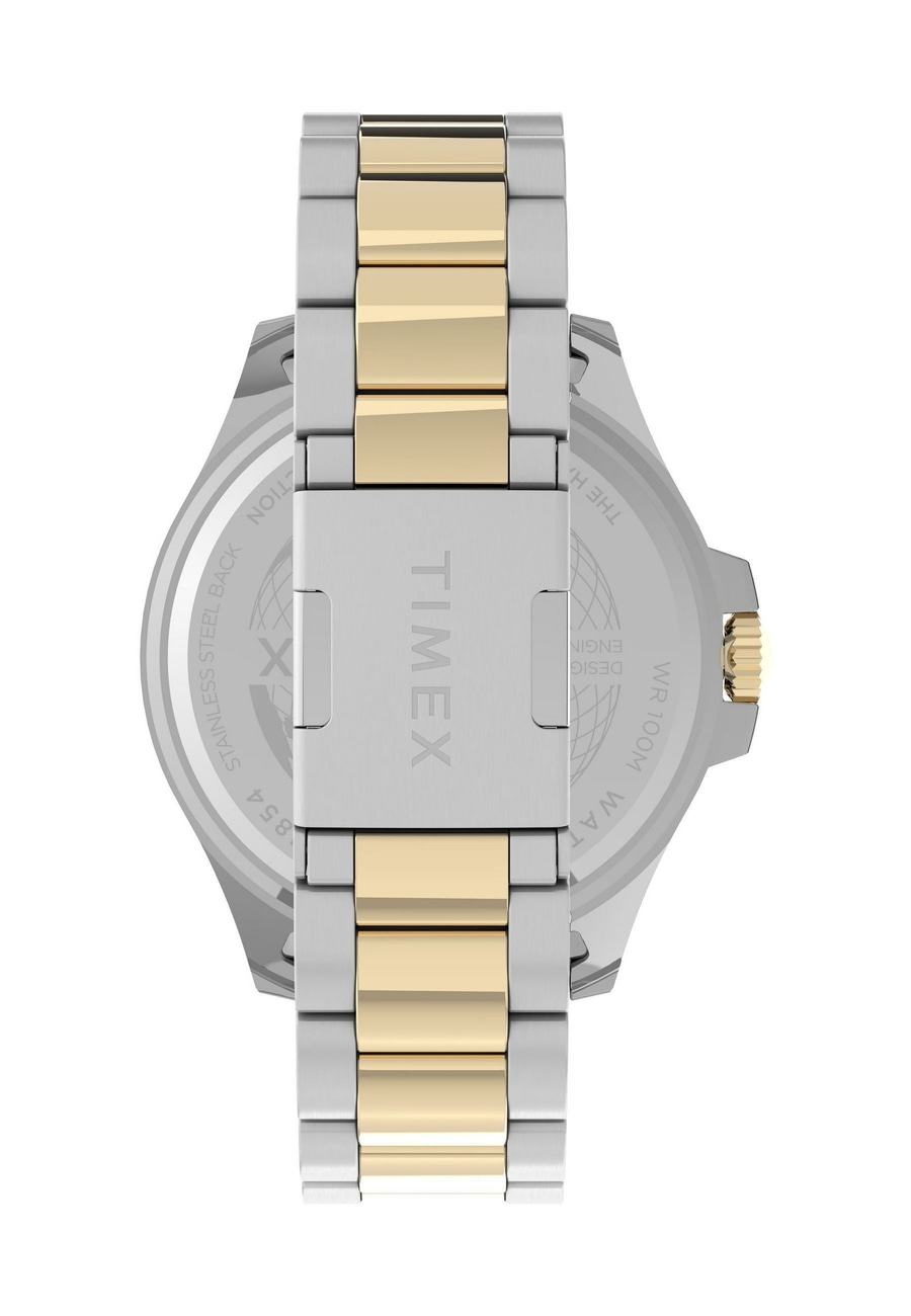 Detailansicht des Rückseitendeckels einer Timex Uhr mit goldfarbenen und silbernen Armbandelementen.