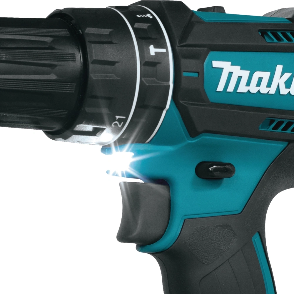 Nahaufnahme eines schwarzen und türkisfarbenen Makita-Akkuschraubers mit einem hellen Lichtstrahl.