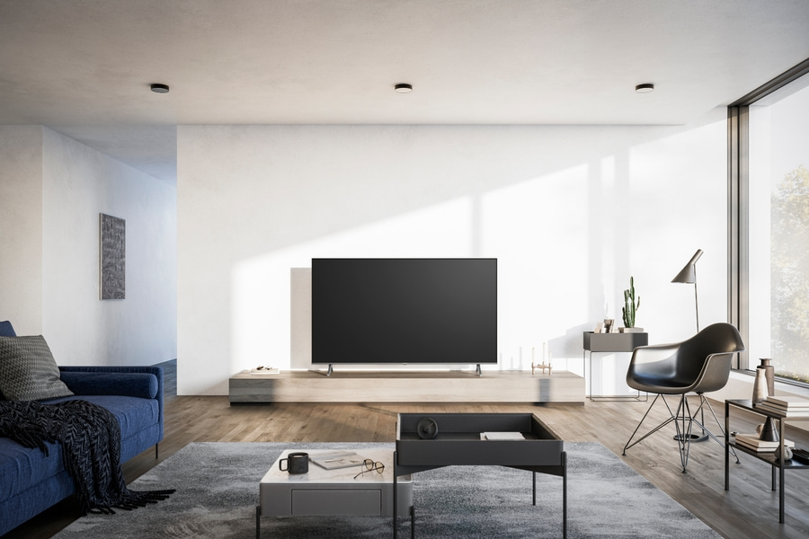 Wohnzimmer mit Fernseher, Couch, Tisch und Stuhl. Modernes Interieur mit Tageslicht.