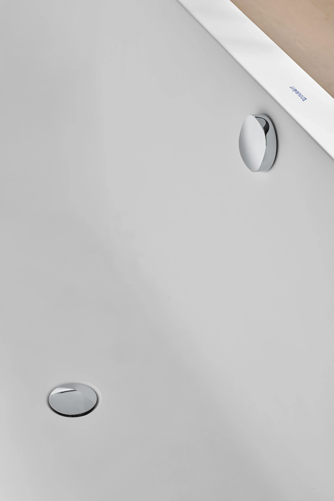 Badezimmer mit zwei verchromten Knöpfen und Duravit-Logo auf weißem Hintergrund