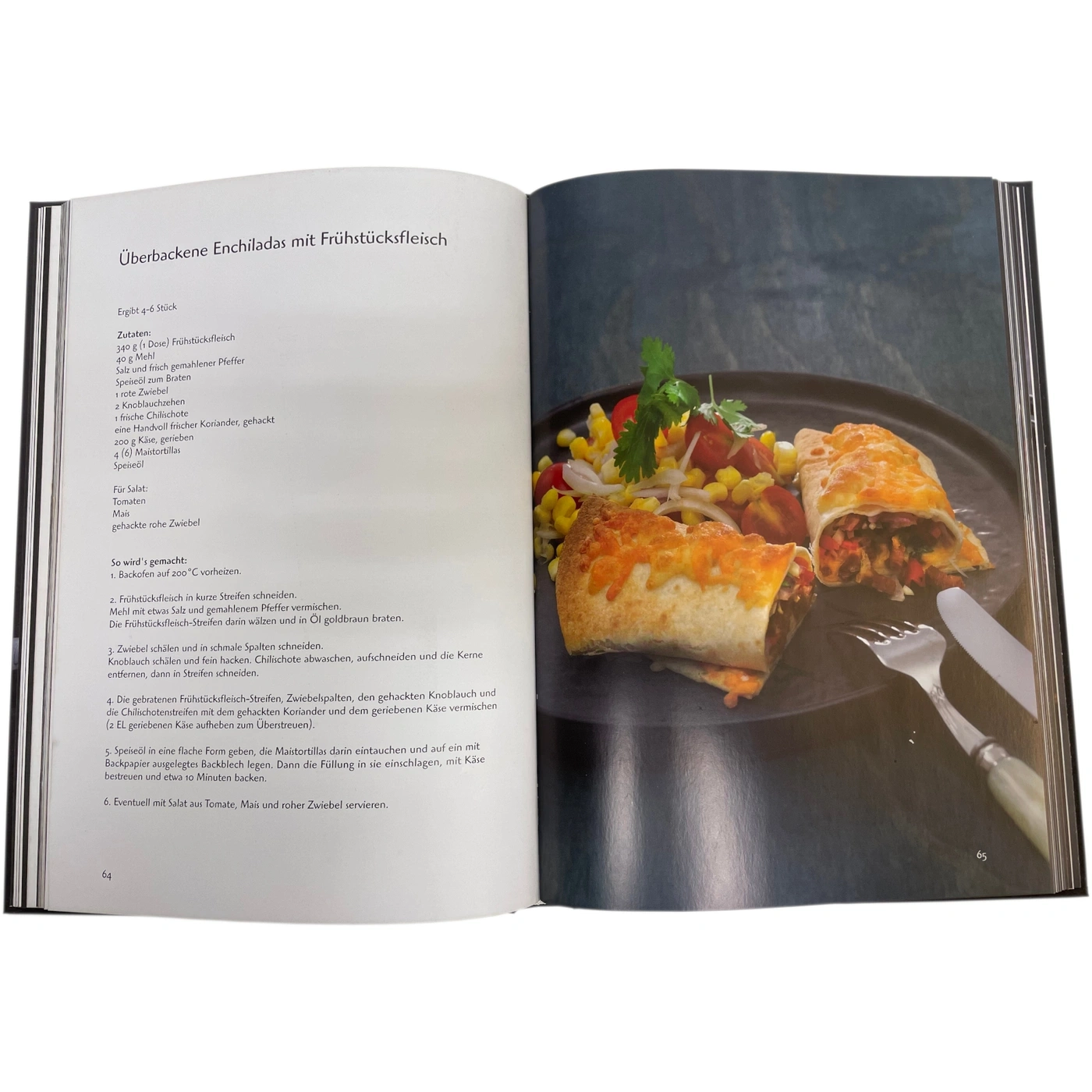 Ein Kochbuch zeigt überbackene Enchiladas mit Frühstücksfleisch und Salat.