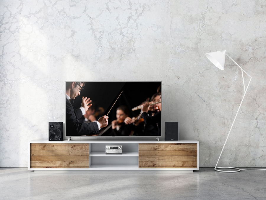 Fernseher mit Musik auf einem Lowboard, Lampe und Lautsprecher