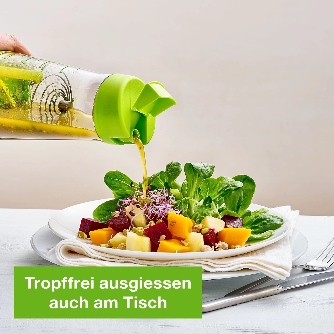 Salat mit Dressing, das aus einer Flasche gegossen wird, auf einem Tisch