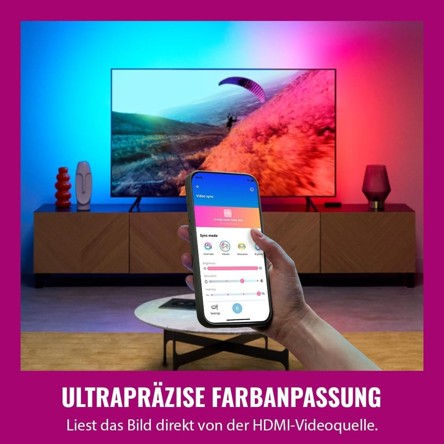 Eine Hand hält ein Smartphone, das die Farbsteuerung für ein Fernsehgerät anzeigt, das mit LED-Licht synchronisiert ist.