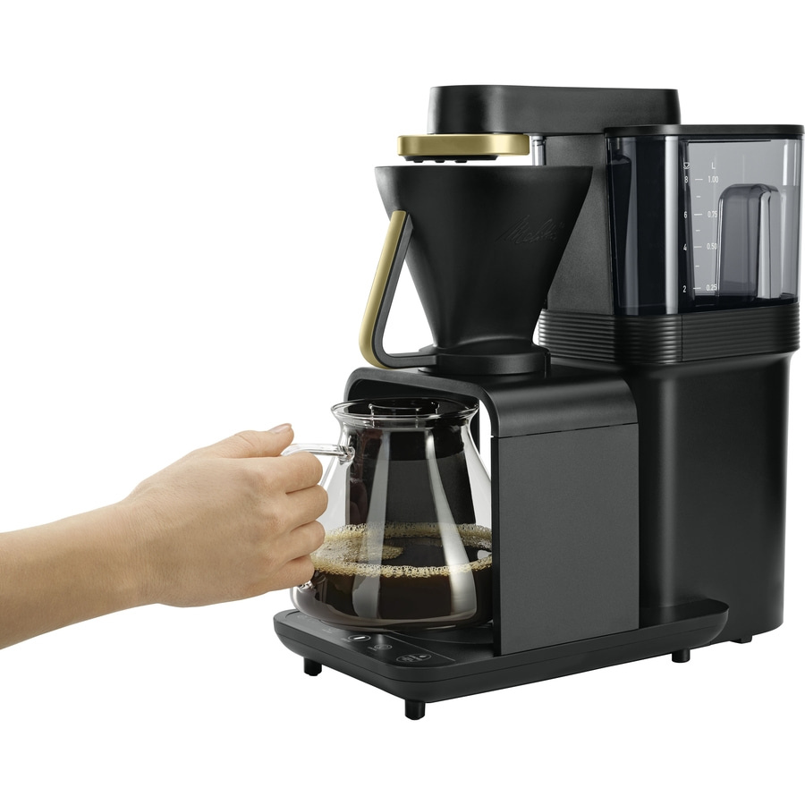 Kaffeemaschine mit Kanne, die von einer Hand gehalten wird, vor weißem Hintergrund