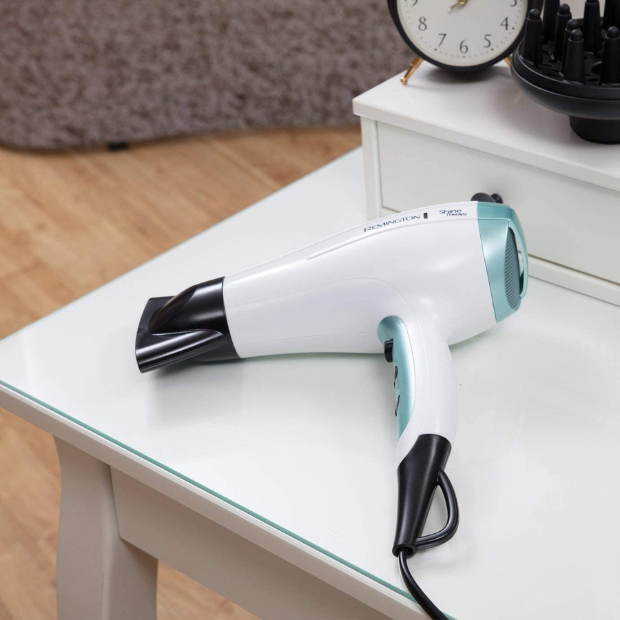 Haartrockner auf einem Tisch. Weiß und blau. Remington Shine Therapy.