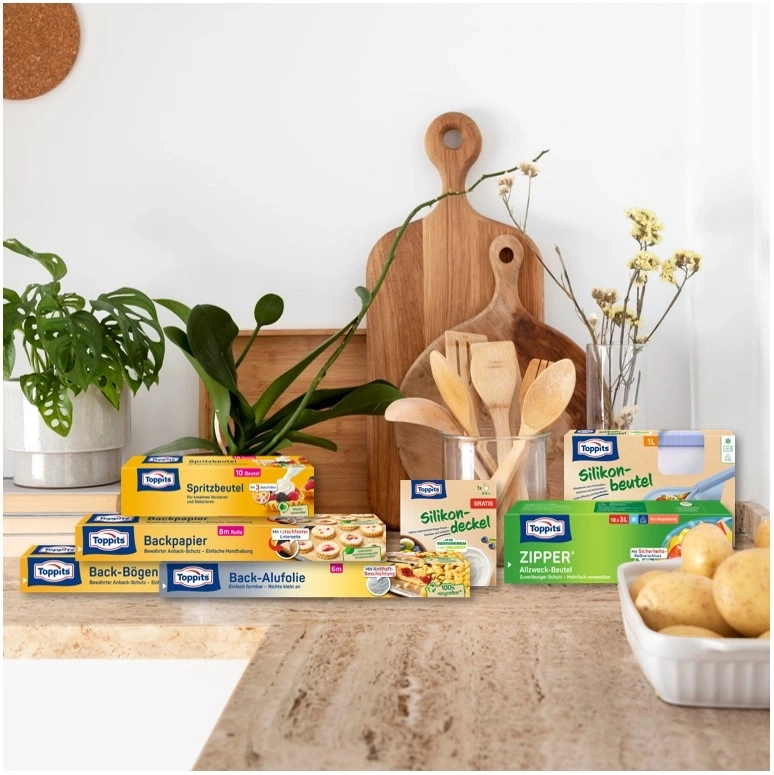 Küchenutensilien mit Toppits-Produkten, darunter Backpapier und Spritzbeutel.