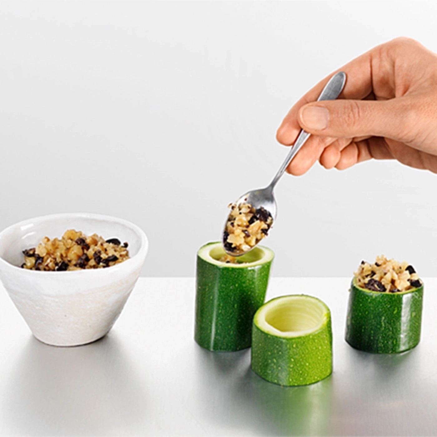 Gefüllte Zucchini mit Löffel. Gemüse wird gefüllt. Nahaufnahme.