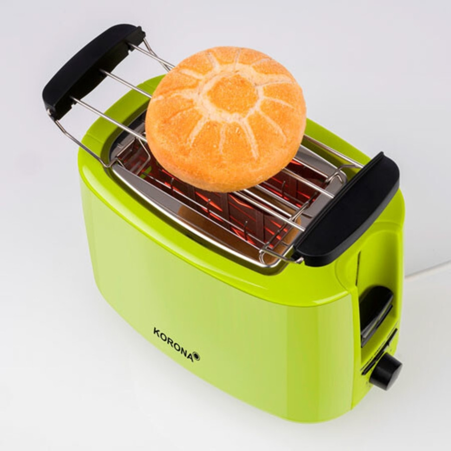 Ein grüner Toaster mit einem Brötchen. Das Brötchen ist auf dem Toaster.