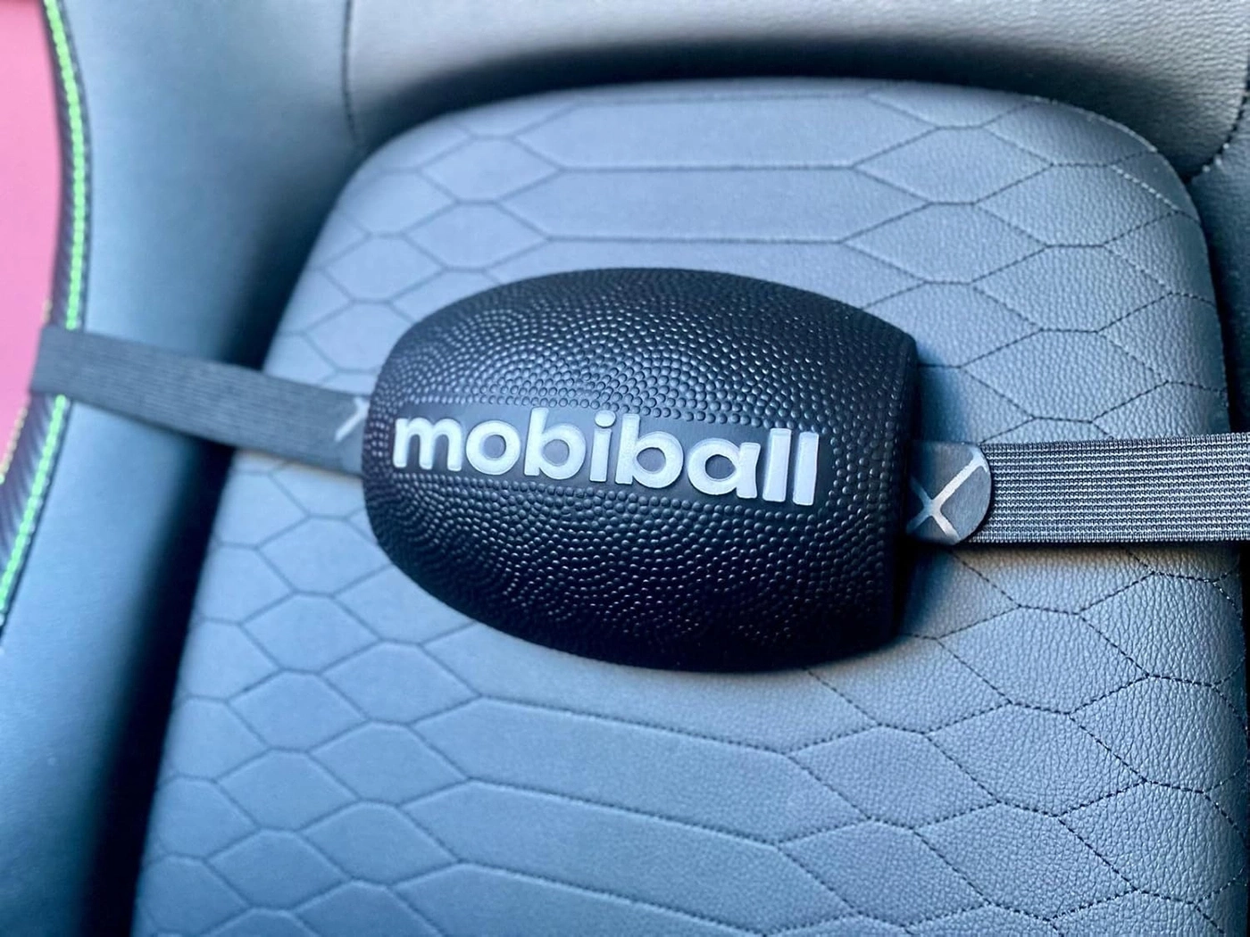 Schwarzer mobiball auf einem Stuhl mit sechseckigem Muster und Gurt