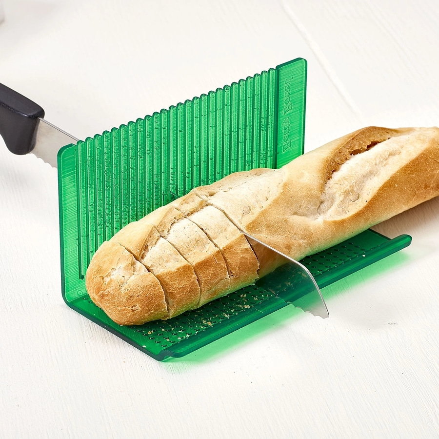 Brot wird mit einem grünen Brotschneider geschnitten. Baguette und Messer.