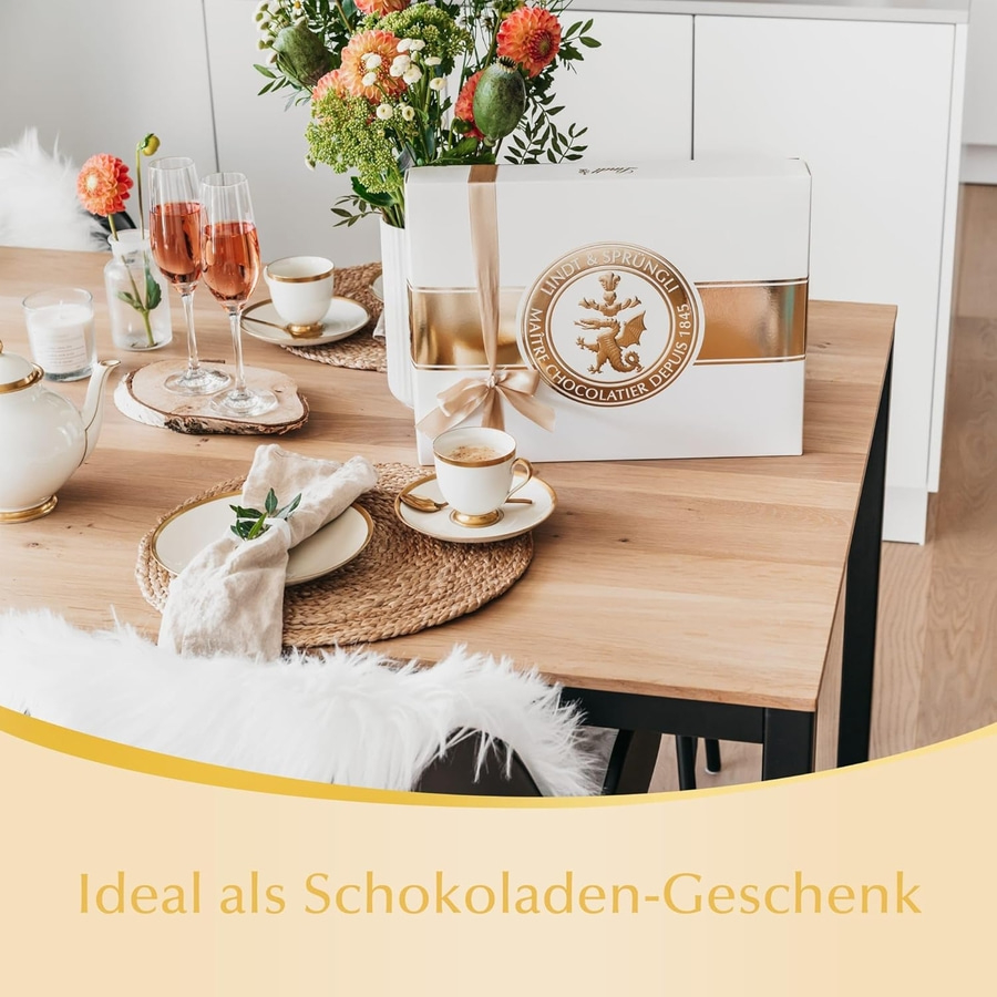 Ein Tisch mit Schokolade, Champagner und Blumen, ideal als Geschenk.