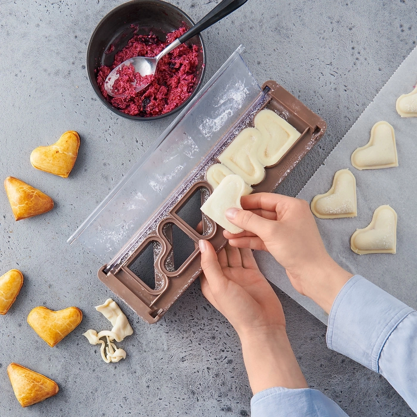 Person macht herzförmige Teigtaschen mit Füllung, Nahaufnahme, Essen