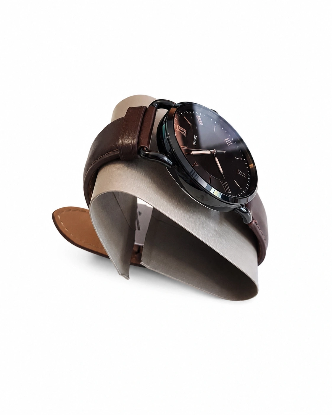 Eine schwarze Fossil-Uhr mit braunem Lederarmband auf einem Ständer.
