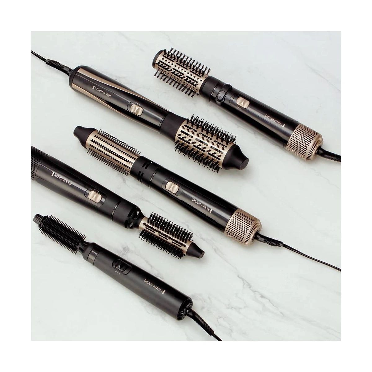 Haarbürsten von Remington auf weißem Marmor. Schwarze und goldene Geräte.