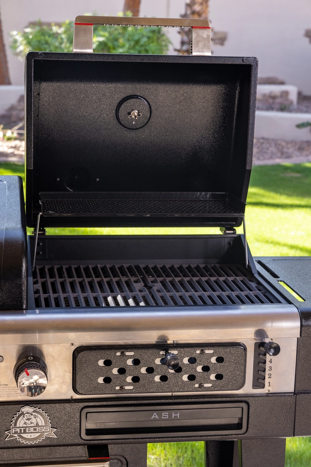 Ein offener Grill mit Metallgrillrost und Bedienfeld.