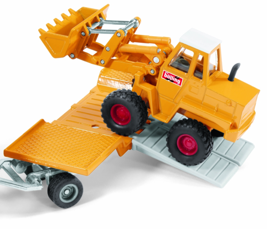 Gelber Spielzeug-Radlader auf einem Anhänger mit roten Felgen und schwarzem Reifen