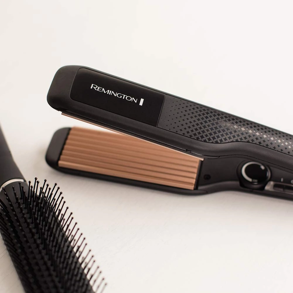 Haarglätter von Remington und Haarbürste auf weißem Hintergrund
