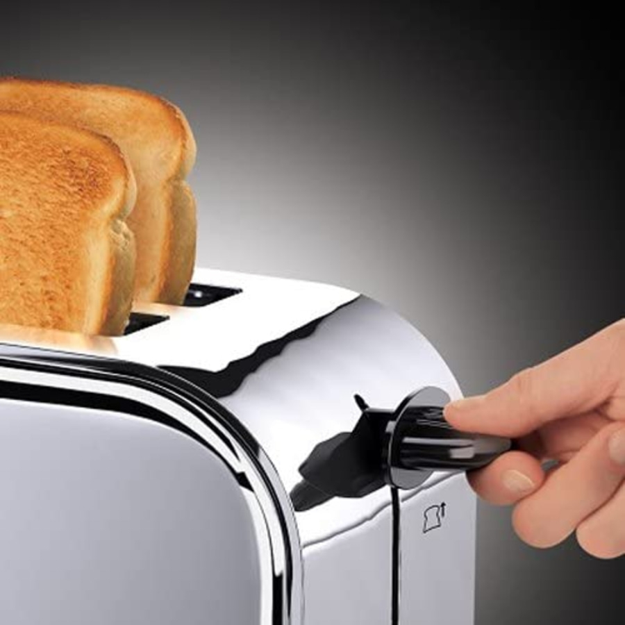 Ein Toaster mit Toast, eine Hand dreht den Bräunungsregler.