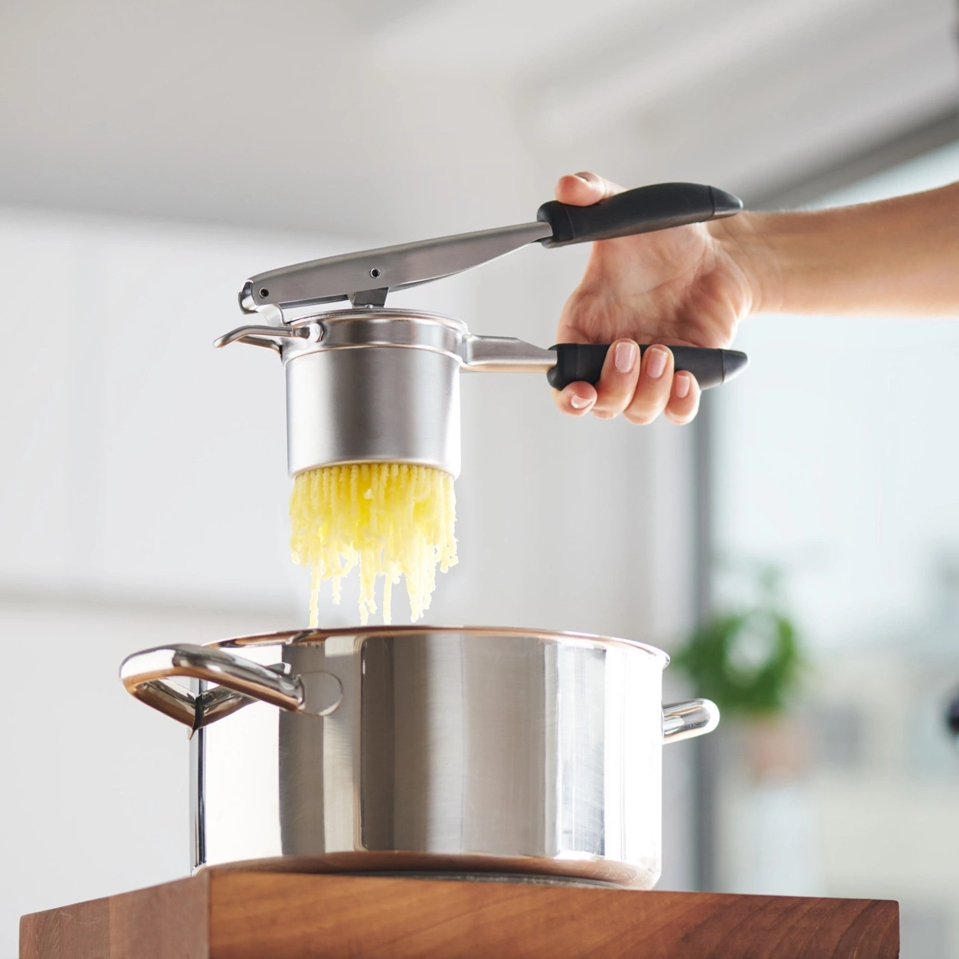 Kartoffelpresse über Topf, Kartoffeln werden gepresst, Küche, Kochen, Essen