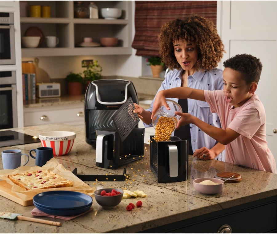 Mutter und Kind machen Popcorn in der Küche. Freude beim Kochen.