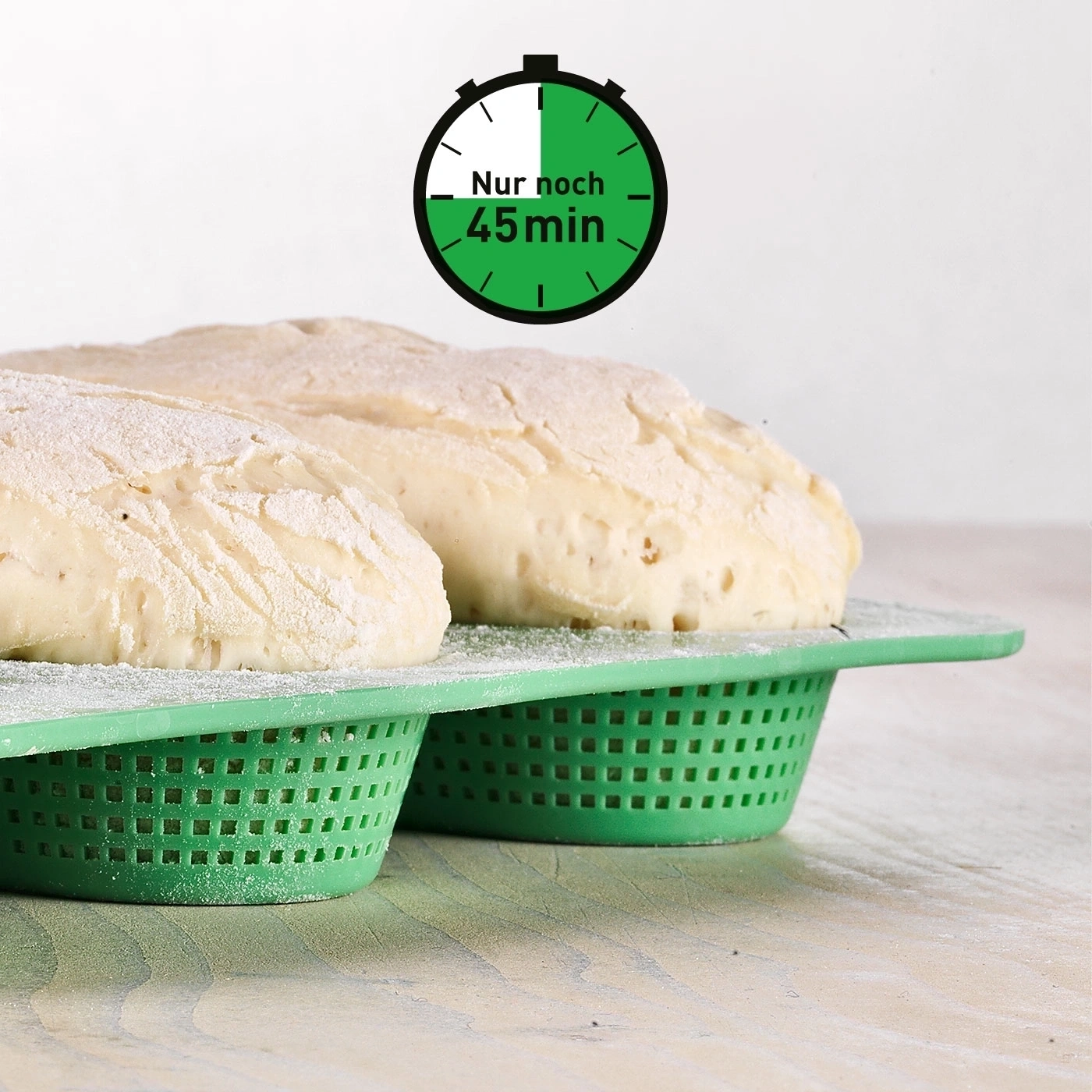 Brotlaibe in grünen Körben mit Timer, der 45 Minuten anzeigt.