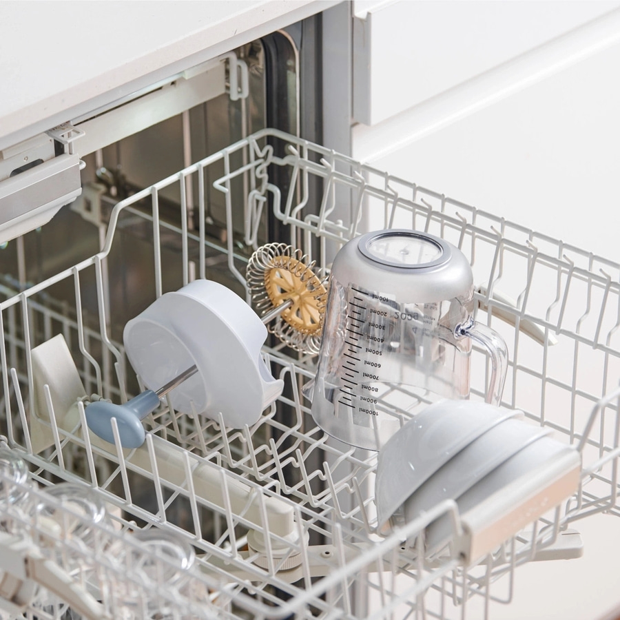 Geschirr in der Spülmaschine. Becher, Schüsseln und Küchenutensilien.